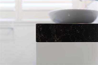 Gloss white bathroom cabinet with dark marble-effect benchtop and oval basin