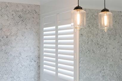 Pendant bathroom lighting complementing neutral grey tiles and plantation shutters by Adelaide Bathrooms