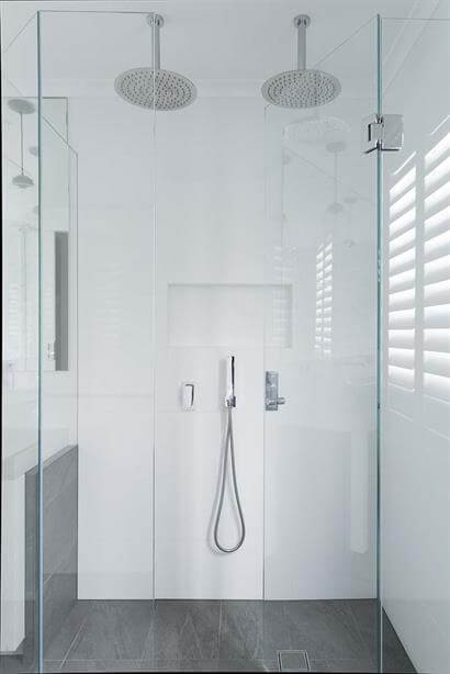 Large frameless shower with twin overhead roses and streamlined wall inset