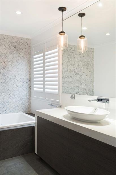 Stone and timber accents with bare pendant lights gives bathroom an industrial feel 