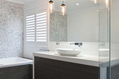 Luxury bathroom in shades of grey with warm timber grains and modern lighting