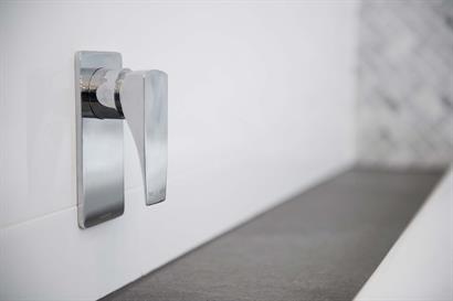 Phoenix wall-mounted tap mixer in chrome combining square edges and soft curves