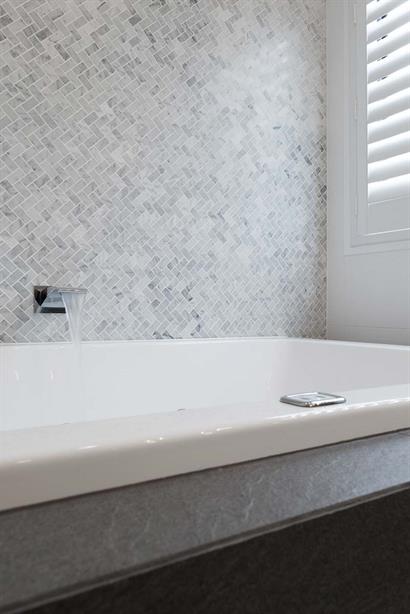 Elegant waterfall tap filling spa bath in luxury bathroom