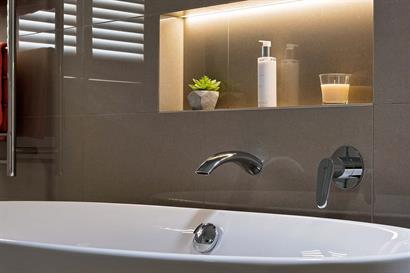 Intimate bathroom mood lighting with backlit wall inset