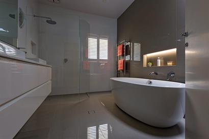 Contemporary freestanding bath with backlit wall inset