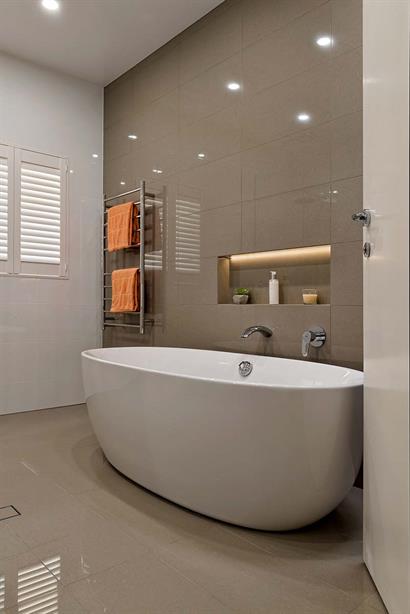 Contemporary bathroom with deep oval bath and floor-to-ceiling tiles