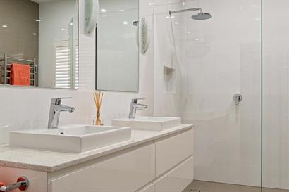 Convenient twin basins set in stone benchtops and white gloss cabinets