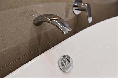 Streamlined wall-mounted bath spout in chrome