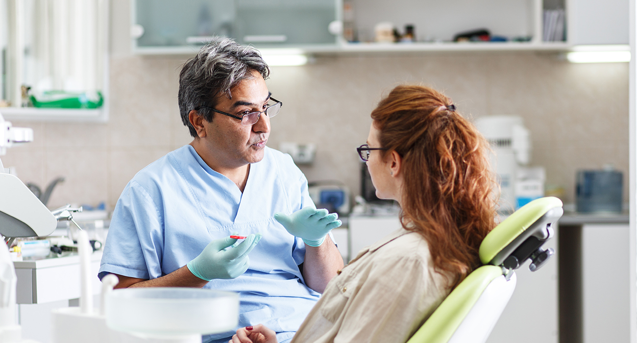 Urgent Dental Care Huntington Park dentist talking with patient about their teeth