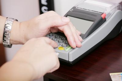 hand entering PIN at ATM