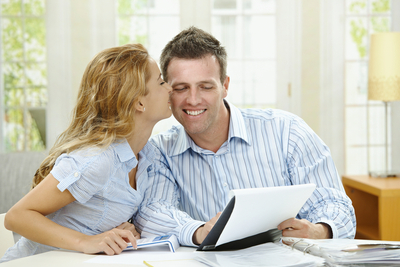 happy couple working on finances at home