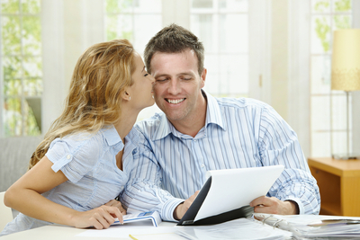 happy couple works on finances at home