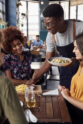 waiter serves a group of female friends