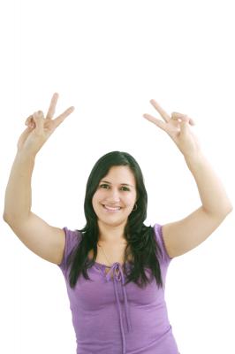 smiling woman makes victory sign with hands