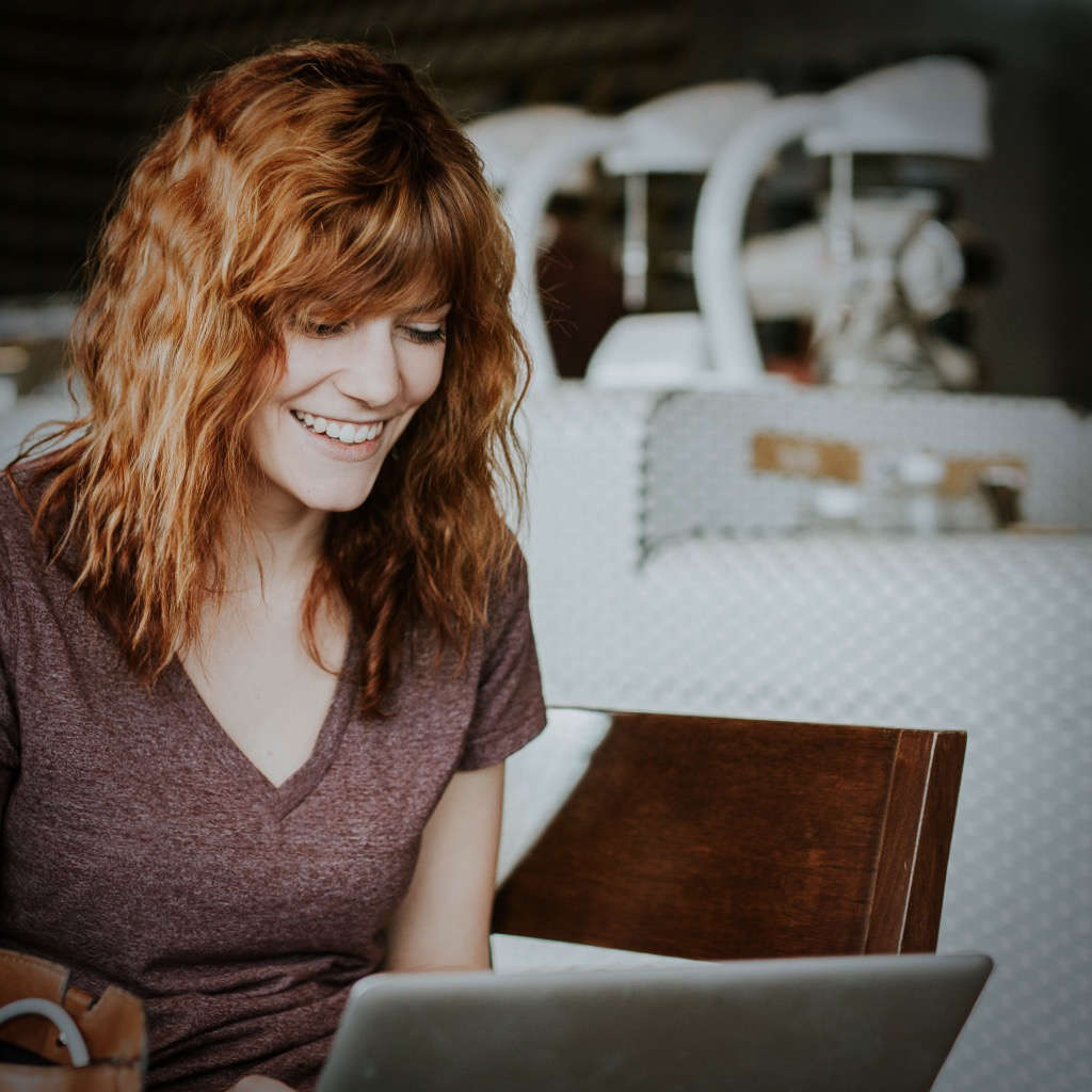 woman looking delighted at her laptop