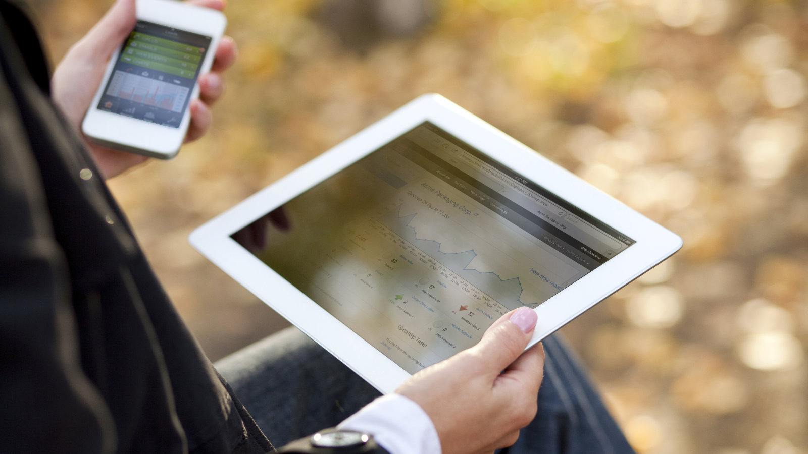 photo of client viewing a website dashboard on a tablet and advertising results on a phone