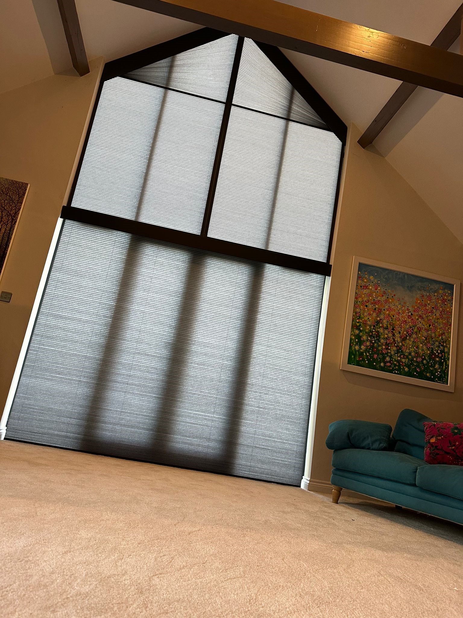 White pleated blinds on a black framed gable window