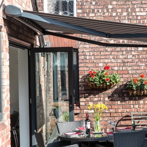 Dark awning over a brick patio with a laid table