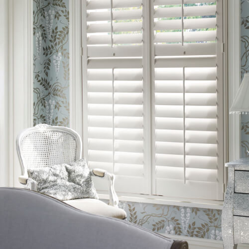 White tier on tier plantation shutters in a bedroom