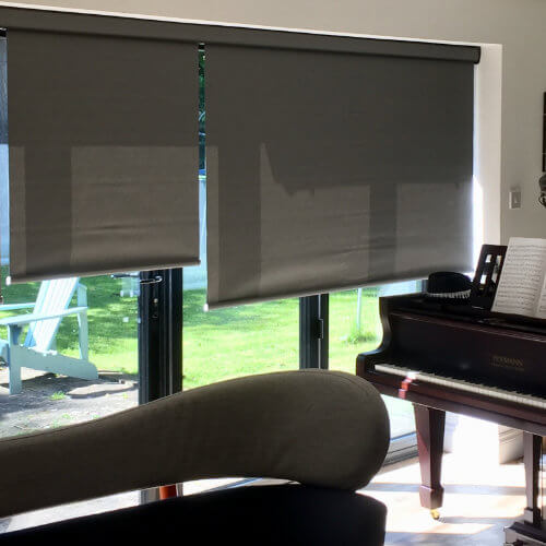 Grey roller blinds across bi-fold doors in a music room