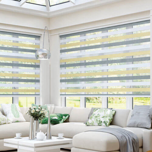 Day and night striped roller blinds across a conservatory window