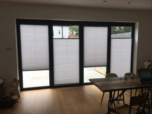 Cream cellular blinds fitted into bi-fold door panels