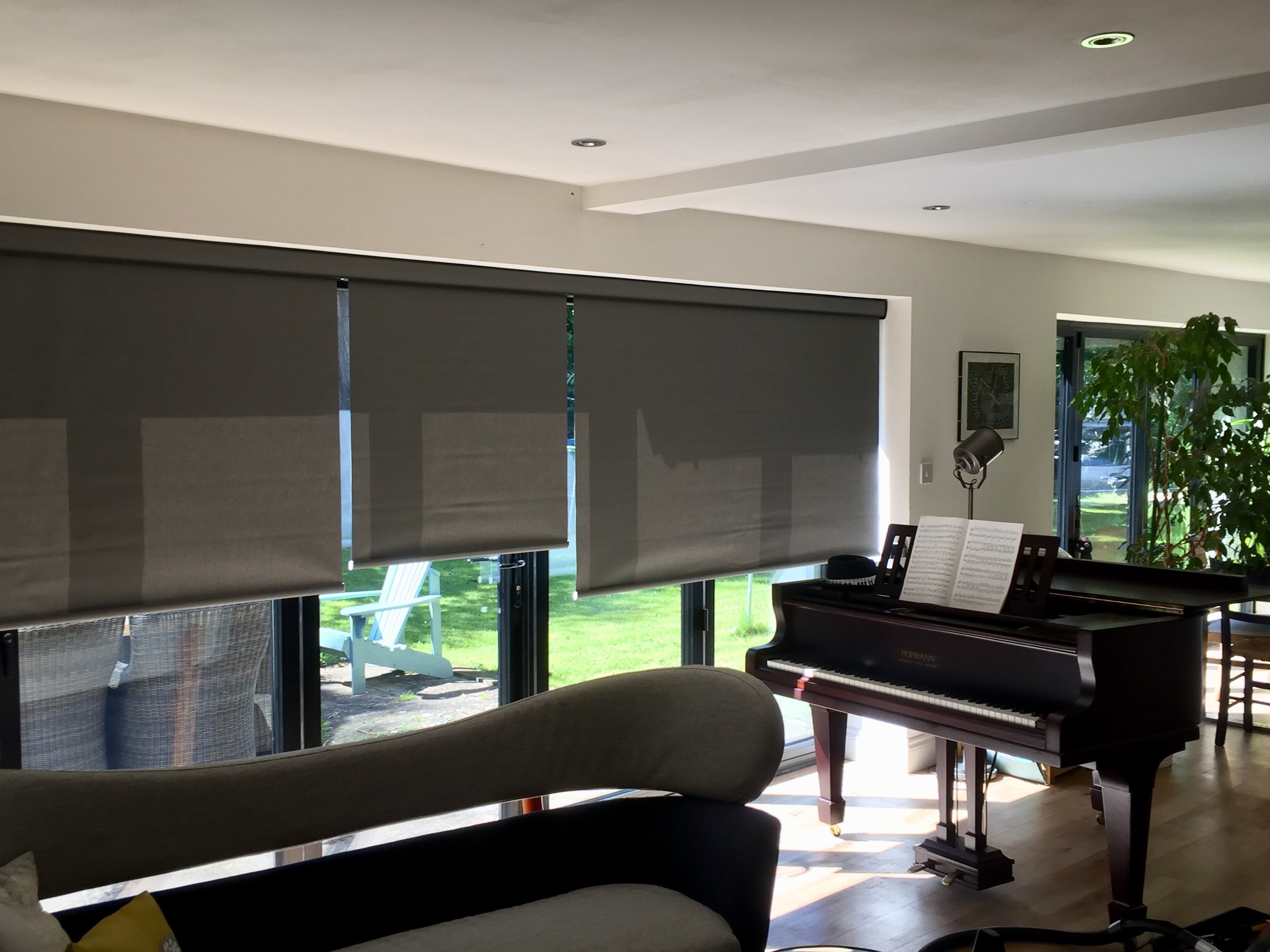 Grey roller blinds over bi-fold doors in a music room