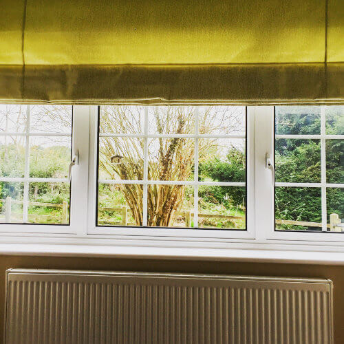 Olive gold roman blind above a radiator