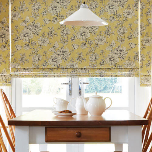 Yellow floral roman blind over a kitchen dining table