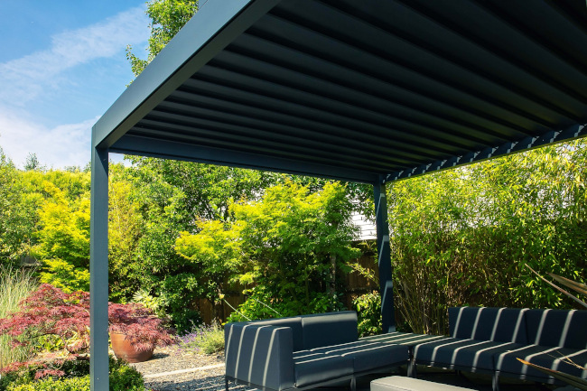 Dark grey louvered roof pod over garden seating
