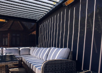 Louvered roof pod interior with a corner sofa and side screen