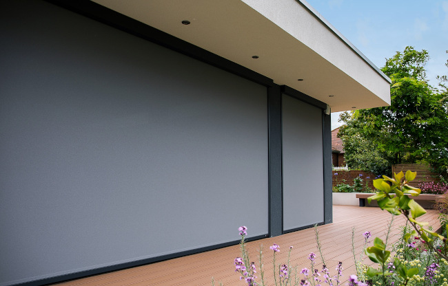 Three external blinds lowered across a garden room