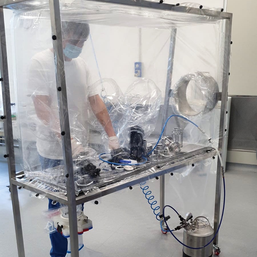 man cleaning parts inside glove bag system