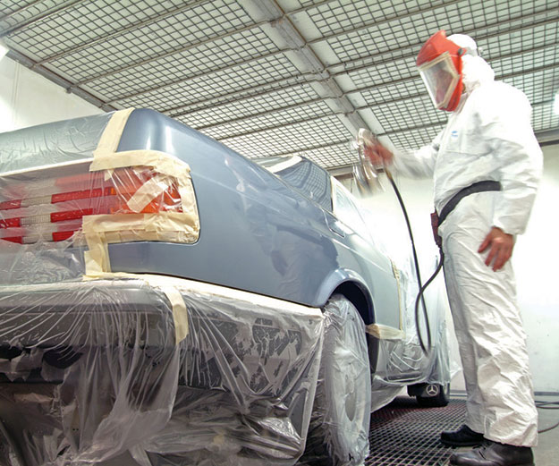 man spray painting a car in an auto body shop