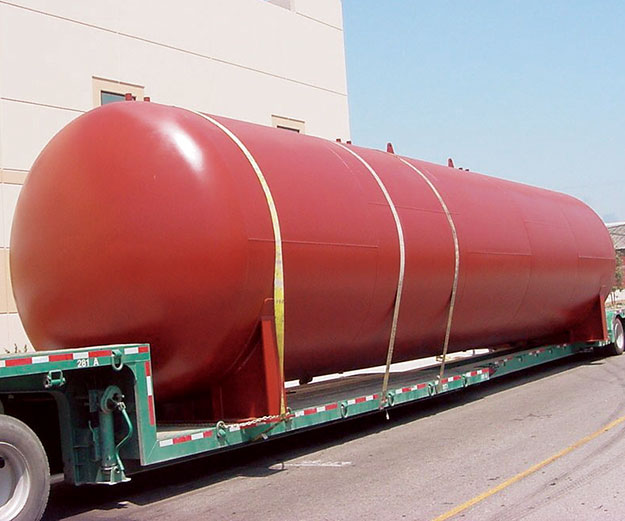 a truck trailer carrying a large painted tank