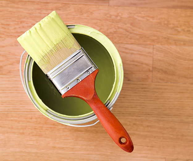 a paintbrush on top of an open can of paint