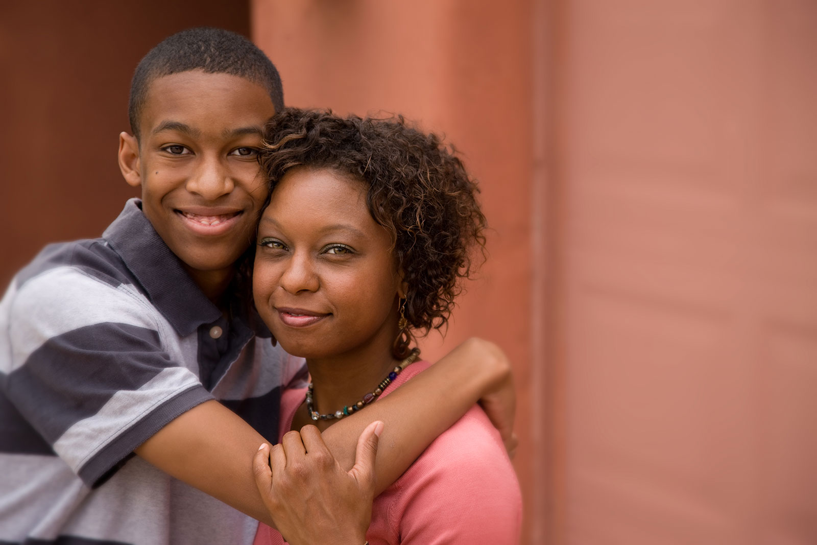 African-American teenager giving his Mom a hug
