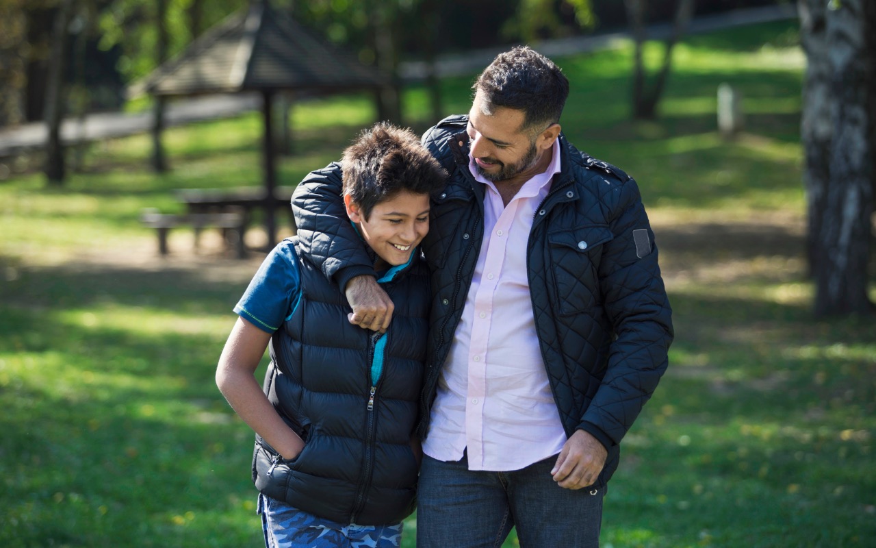 father with arm around his son
