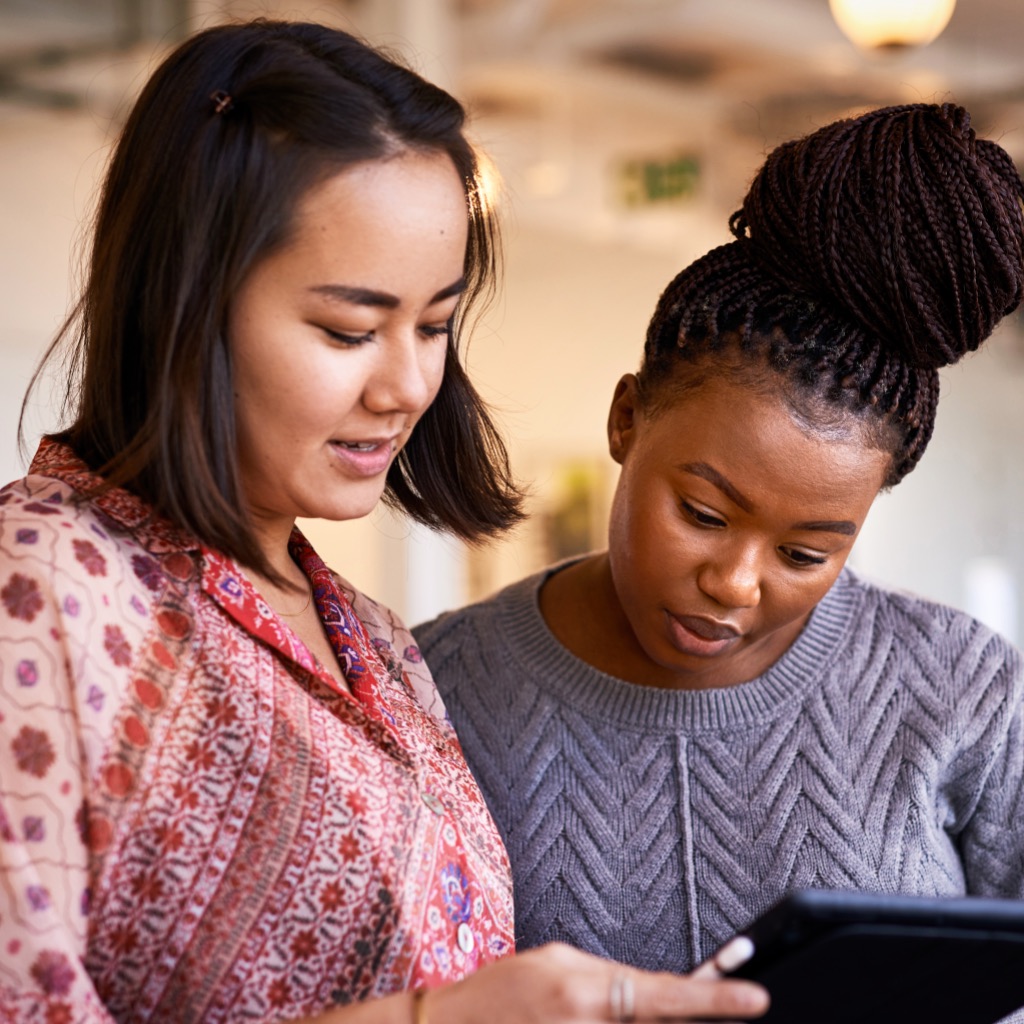 two women discussing notes