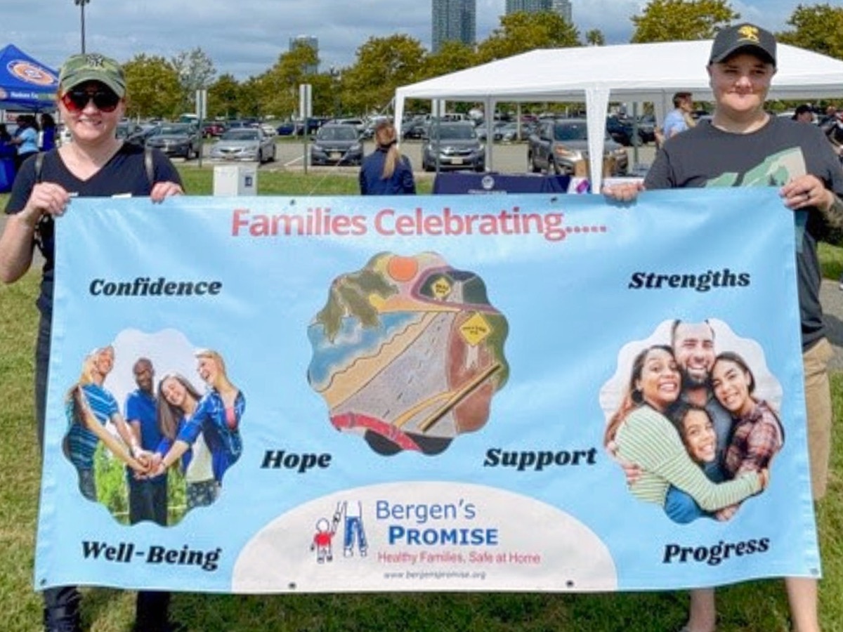 two people holding Bergen's Promise banner
