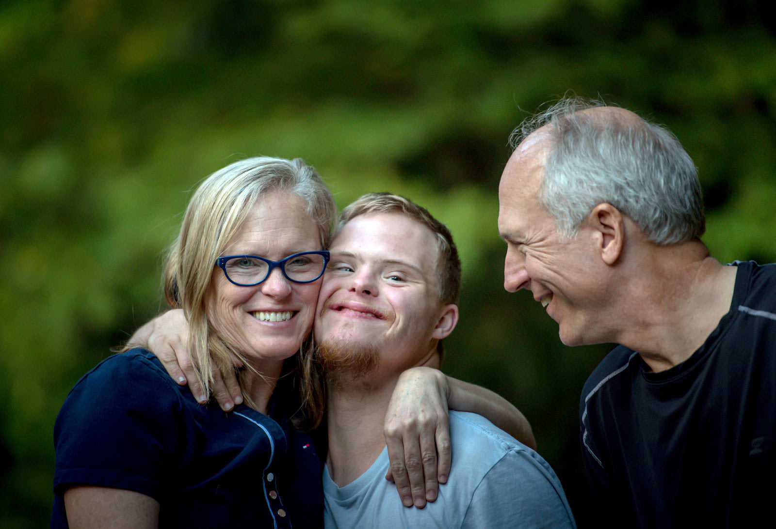 Smiling close up portrait of mother, father and developmentally disabled son