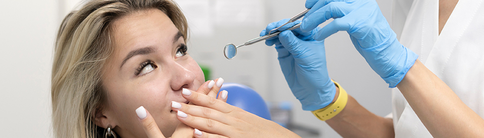 Woman looking at person tyring to work on her teeth