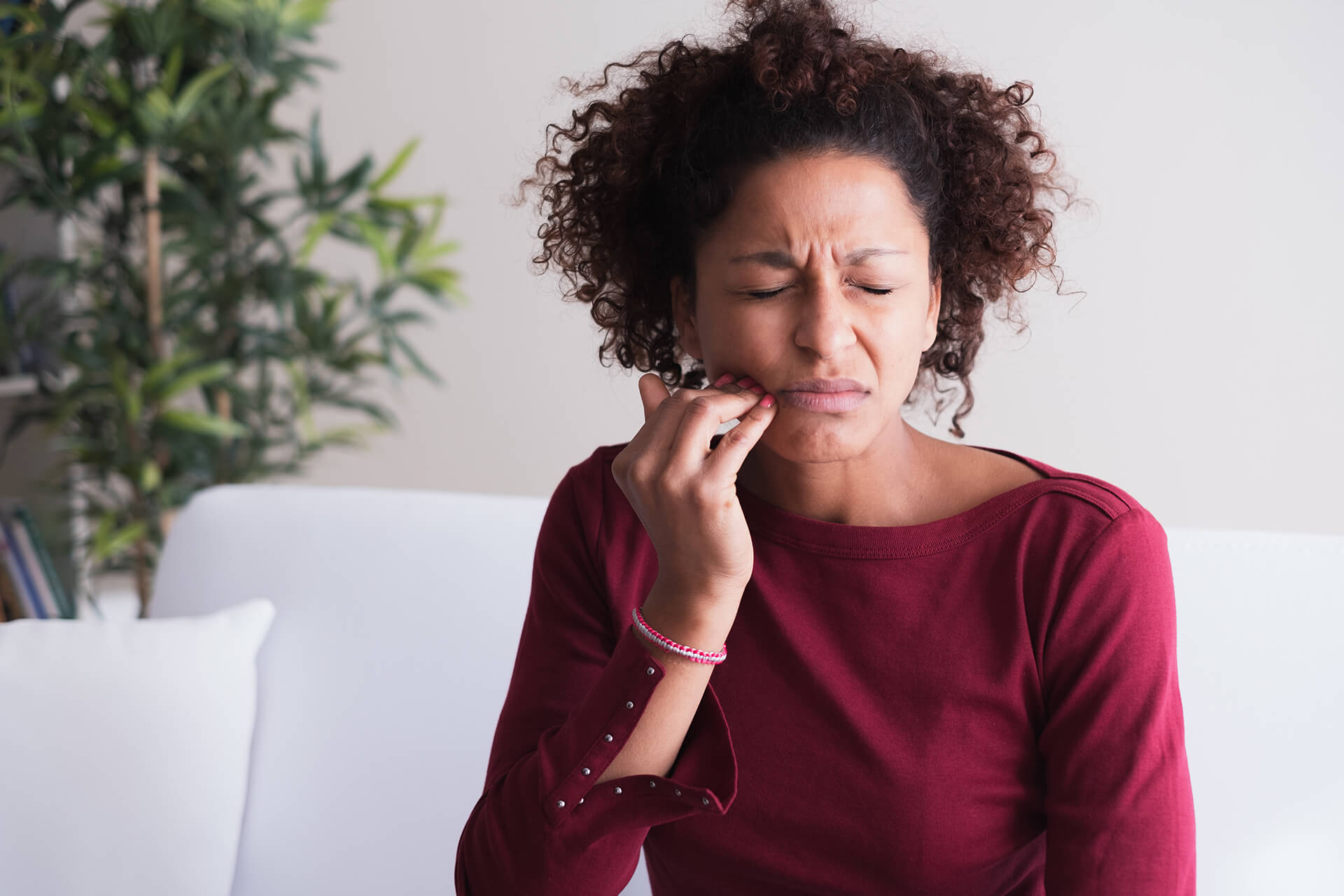 woman holding jaw in pain