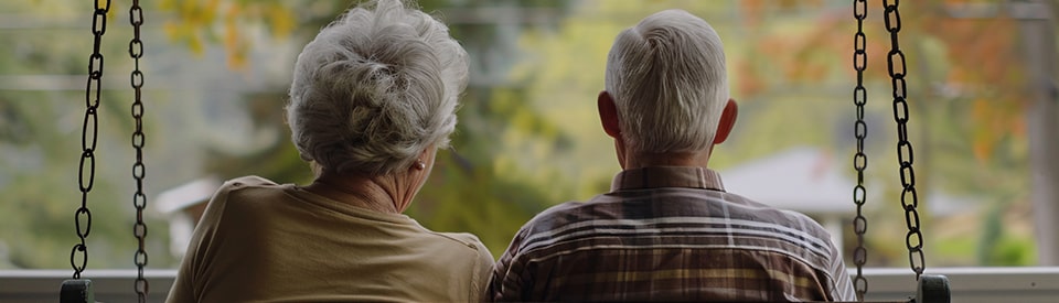 elderly couple sitting on the porch togther