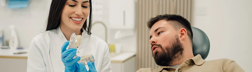 young man discussing dentures with dentist