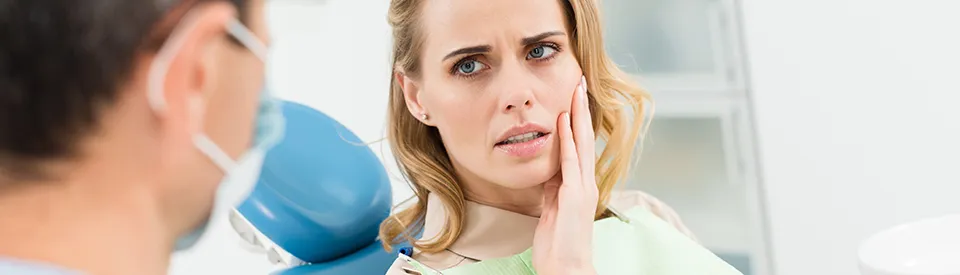 woman holding mouth in in pain