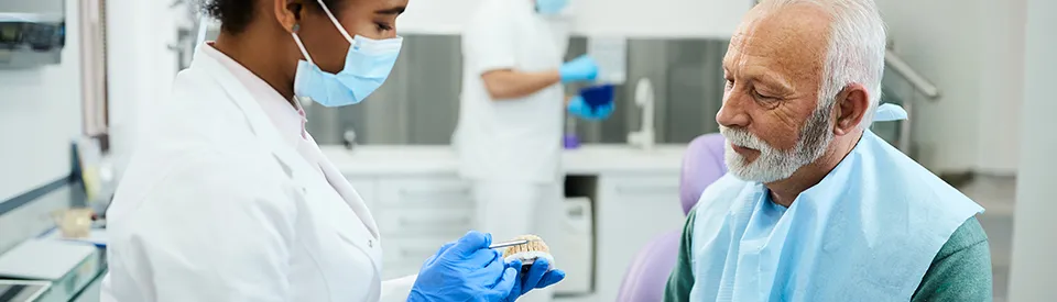 older mand and dentist discussing denture