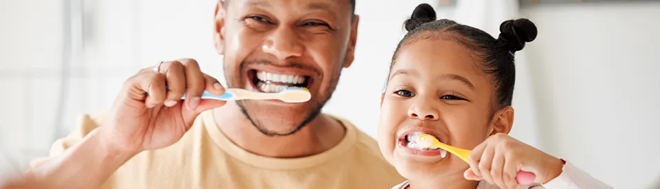 father and daughter brushing teeth