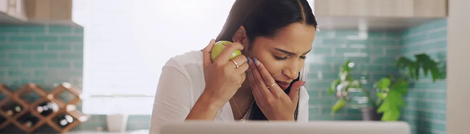 black woman holding jaw from tooth pain