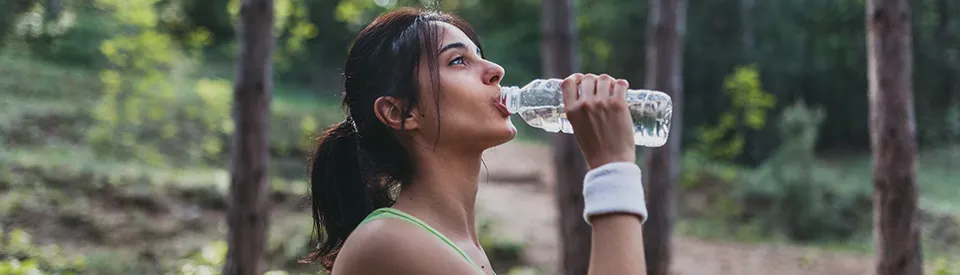 woman drinking water in the forest